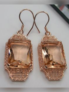 Simulated Peach Topaz Rose Gold plated Sterling Silver EarringsLantern Design#E13 Inspired by the Art Deco period, these lovely antique reproduction earrings are rose gold overlay on sterling silver. Created from an antique brooch, each earring has a 9 carat simulated peach topaz surrounded by filigree. The man-made gemstones are 15mm x 12mm each. The earrings are 1 3/4" long and 9/16" at their widest point. These lovely dangle earrings are marked 925 for sterling silver. These earrings are a wo Elegant Copper Filigree Jewelry, Elegant Rectangular Rose Gold Earrings, Elegant Rose Gold Rectangular Earrings, Rectangular Rose Gold Jewelry For Evening, Elegant Copper Earrings For Wedding, Elegant Rose Gold Filigree Earrings, Elegant Copper Jewelry With Matching Earrings, Elegant Copper Jewelry For Parties, Rectangular Rose Gold Jewelry For Party