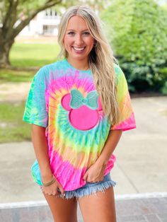 a woman wearing a tie dye mickey mouse shirt