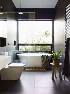 a bath room with a toilet a tub and a window