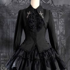 A gothic blouse that looks like an aristocratic lady from medieval Europe. Her collar has a cross sword embroidered on it, the back is laced, and the chest is decorated with a statement frill. She is a mysterious young lady with a gorgeous aura. 
 
 

 

 
 
 
 Size 
 
 XS size 
 
 Length: 63cm 
 Bust: 84cm 
 Waist: 72cm 
 Sleeve length: 62cm 
 
 S size 
 
 Length: 64cm 
 Bust: 88cm 
 Waist: 76cm 
 Sleeve length: 62cm 
 
 M size 
 
 Length: 65cm 
 Bust: 92cm 
 Waist: 80cm 
 Sleeve length: 62.5cm Gothic Blouse, Medieval Europe, Ribbon Headbands, Long Holiday, Jumper Skirt, Ribbon Hair, Gothic Lolita, Blouse Black, Sheer Blouse