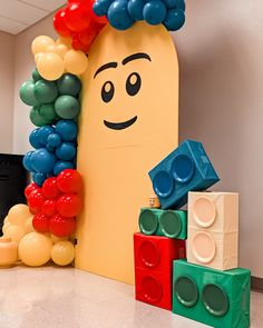 there is a large balloon sculpture made to look like a lego man with balloons on his head