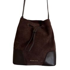 A Michael Kors Bucket Bag From The Cary Collection Crafted In Suede And Smooth Leather And Gold Hardware. This Bucket Bag Features 1 Main Compartment, Drawstring Closure, A Zip Pouch With Pocket, And An Adjustable Strap With A 18"-20.5" Drop. Dimensions: 10.5"W X 11.25"H X 5.75"D. Brand New, Never Been Used. Perfect Condition. Classic Brown Bag With Dust Bag, Classic Brown Soft Leather Bucket Bag, Classic Brown Crossbody Bucket Bag, Michael Kors Brown Shoulder Bag For Travel, Michael Kors Travel Pouch Bag, Michael Kors Brown Everyday Bags, Michael Kors Brown Bag With Removable Pouch, Michael Kors Brown Shoulder Bag For Everyday, Michael Kors Brown Everyday Shoulder Bag