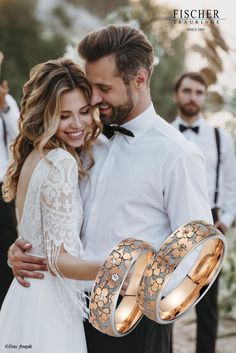 a man and woman standing next to each other wearing wedding rings