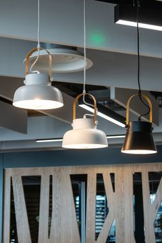 three lamps hanging from the ceiling in an office