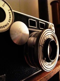 an old camera sitting on top of a wooden table