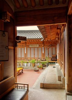 the inside of a building with plants and benches