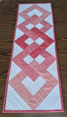 a pink and white quilted table runner