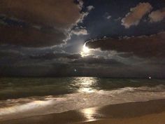 the sun shines through clouds over the ocean on a cloudy day at the beach