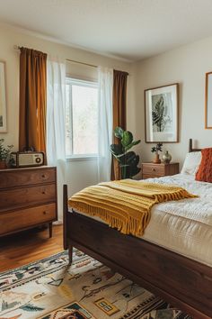 a bed sitting in a bedroom next to a window with curtains on the windowsill