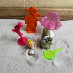 various toy figurines are sitting on the white towel in front of a wall