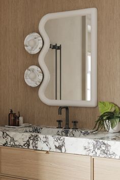 a bathroom vanity with marble counter top and mirror