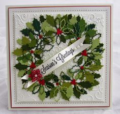 a christmas card with holly wreath and ribbon