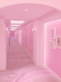 a hallway with pink walls and pictures on the wall