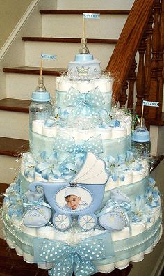 a blue and white diaper cake sitting on top of a stair case