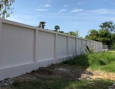 a white fence next to a grassy field