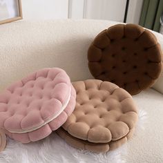 three round cushions sitting on top of a white couch