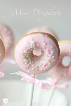 pink donuts with sprinkles are on a stick