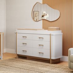 a baby's room with a dresser, crib and mirror on the wall