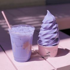 an ice cream sundae next to a purple cup