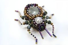 a beaded brooch with pearls and beads on it