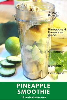 a blender filled with pineapple and cucumber next to sliced limes