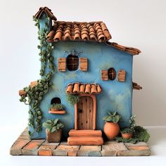 a clay house with plants and potted plants