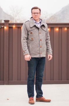 a man standing in front of a fence with the words shwn & shwin on it