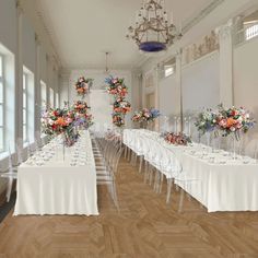 a room filled with lots of tables covered in white tablecloths and flowers on top of them