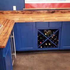 a wine rack in the corner of a kitchen with blue cabinets and countertops