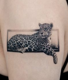 a black and white photo of a leopard on the back of a woman's arm