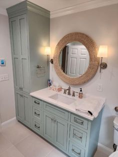 a bathroom with two sinks and a large round mirror above the sink is painted light blue