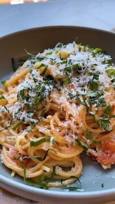 a plate of pasta with tomatoes and parmesan cheese