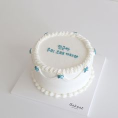 a white cake with blue writing on it