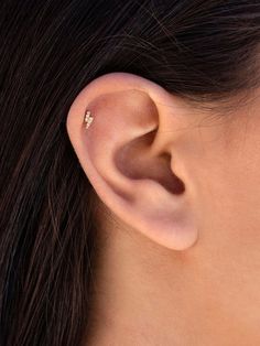 a woman's ear is shown with a small diamond in the middle of it