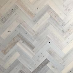 a white and grey herringbone pattern on the wall in a room with wood floors