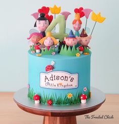 a birthday cake with the number four on it and many small figurines in front of it