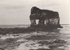 an old black and white photo of rocks in the ocean