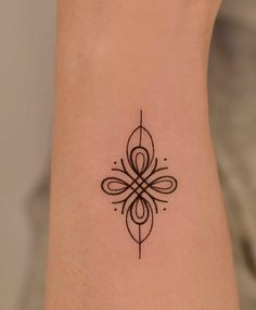 a small tattoo on the ankle that is black and white with an intricate design in the middle