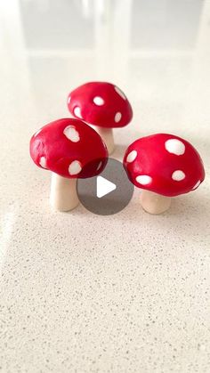 three red mushrooms sitting on top of a white counter