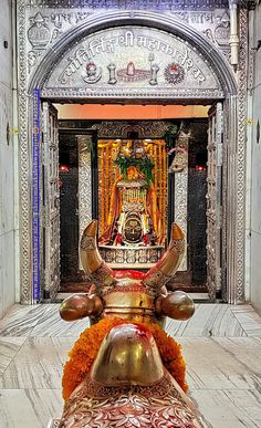 an ornate statue in the middle of a building with gold and red decorations on it