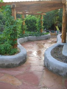 an outdoor garden area with stone walls and raised planters, surrounded by greenery