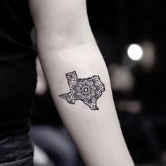 a woman's arm with a black and white tattoo design on the left forearm