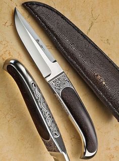 a knife and sheath on a table next to each other with a leather case around it