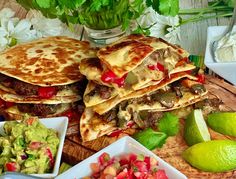 there are many different foods on the table and one is cut in half to make quesadillas