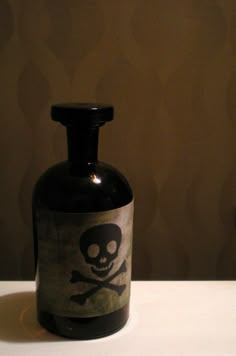 a black bottle with a skull and crossbones on the side sitting on a table