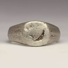 This handmade signet ring has a little 1.2mm Champagne diamond bead set for a subtle sparkle. The face is 10x10mm with a tapering shank for comfort.  Made by casting recycled sterling silver in beach sand, it has a lovely chunky feel. The sand mould creates the texture you can see on the ring. The ring pictured is a size M. Your ring will be made to order and each one comes out differently.  The rustic and irregular nature of our sandcast range comes from Justin's own technique; as the name suggests each ring is cast in beach sand. With a different mould used each time, every ring is totally unique - make it that little bit more special by sending us your own beach sand.   You can buy the mould the ring is cast in if you like. If you would like to use some of your own metal or sand please Mens Jewellery, Diamond Signet Ring, Signet Rings, Silver Signet Ring, Thumb Ring, Bead Set, Ring Pictures, Shiny Things, Thumb Rings