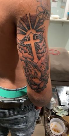 a man with a cross tattoo on his arm