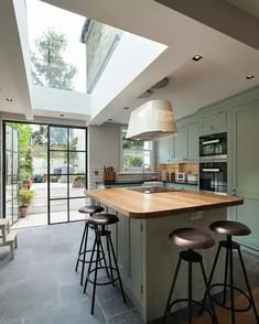 an open kitchen with skylights and stools