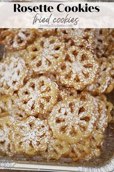 powdered sugar coated cookies in a baking pan with the words, rosette cookies fried cookies