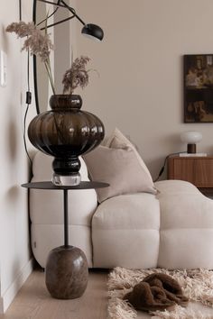 a living room filled with furniture and a large vase sitting on top of a table